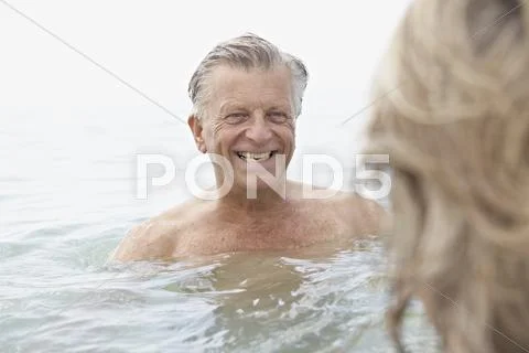 Spain, Senior couple swimming in sea Stock Photos