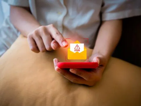 Spam detection and cybersecurity concept. Person using smartphone with spam.. Stock Photos