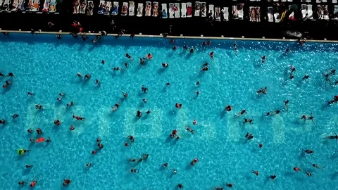 The span of the camera from the people who sunbathe to the pool Stock Footage 93449161