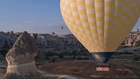 The span of a large yellow balloon, in a basket of people, close-up Stock Footage 105474700