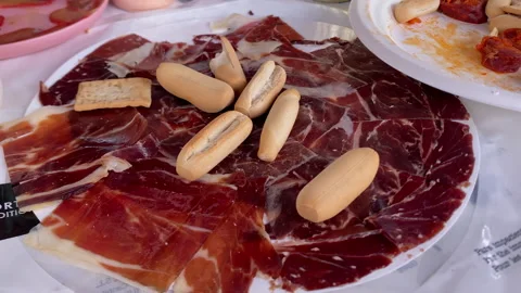 Spanish cured ham with breadsticks enjoying tapas Stock Footage 336608089