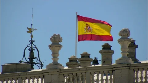 Spanish flag blowing in wind on flagpole on roof Video stock 95654939