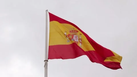 Spanish flag on a flagpole flutters in the wind and cloudy sky Stock Footage 258590436