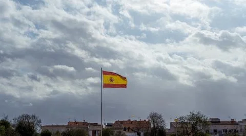 Spanish flag flying in the wind on a cloudy day Stock Photos
