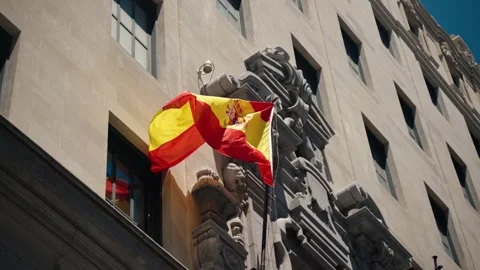 The Spanish flag waves on a stone building facade in central Madrid Spain Vídeos de archivo 322716096