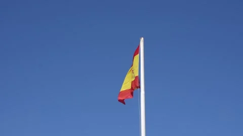 Spanish Flag Waving on Flagpole Against Clear Blue Sky Stockbeeldmateriaal 342621496