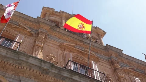 Spanish flag waving in the wind on the balcony of the historic city hall Видео 339001062