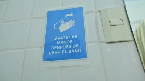 Spanish Language Wash Your Hands After Bathroom Use Sign On Tiled Wall Stock Footage 343908277