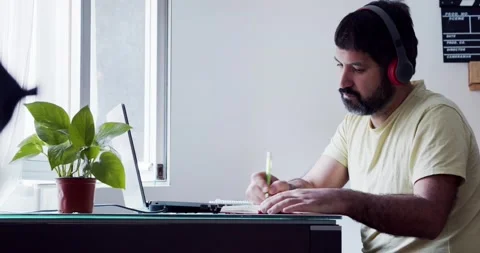 Spanish man writing in a notebook working at home. Frelance remote work concept Stock Footage 166801484