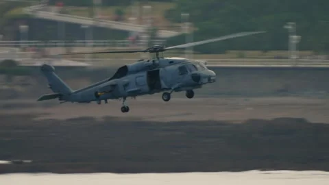 Spanish Navy SH-60 Seahawk low over rocky Gijon beach at airshow Stock Footage 336470430