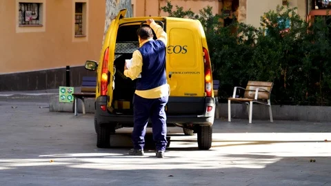 Spanish postal worker loading letters and parcels Stockbeeldmateriaal 115852876