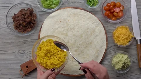 Spanish rice is placed on a tortilla Video stock 294783116
