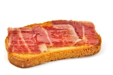 Spanish serrano ham on bread slice. White background. Tapa Stock Photos