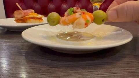 Spanish Tapas: Hand of a Caucasian Man Taking a Shrimp and Olive Skewer in a Stock Footage 334823770