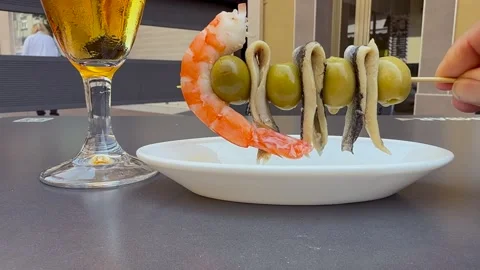 Spanish Tapas: Hand of a Caucasian Man Taking an Anchovie and Olive Skewer Next Stock Footage 337012456