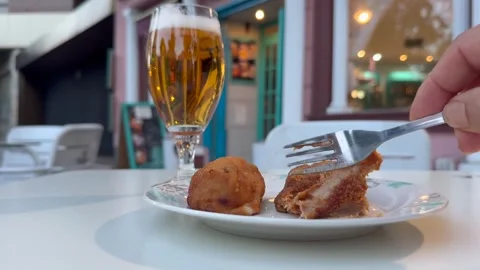 Spanish Tapas: Hand of a Man Eating Homemade Croquettes an Drinking a Beer in a Stock Footage 337012460
