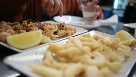 Spanish tapas seafood fish potatoes tortilla hands children family eating Stock Footage 235608637