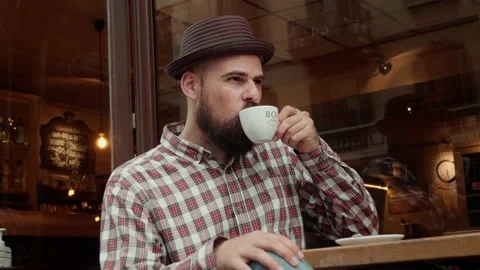Spanish young man drinking coffee close-up. Brutal latin guy drinks tea at Stock Footage 178590294