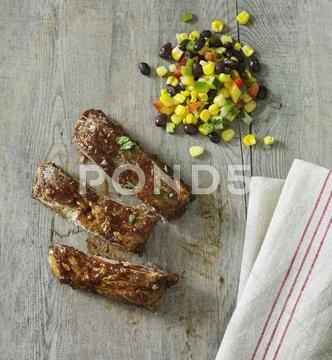 Spare ribs with a bean and sweetcorn salad Stock Photos
