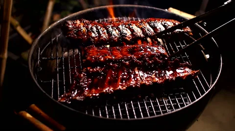 Spare ribs twisting roasting on kettle grill Stock Footage 61347696