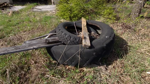 The spare tires and plastic garbage on the ground in Estonia Stock Footage 256456918