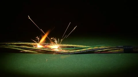 A spark appears in the center of the cable bundle, illuminating the area with fl 動画素材 323025383