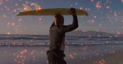 Spark overlay appearing surfer walking shore holding yellow board aloft Stock Footage 331821082