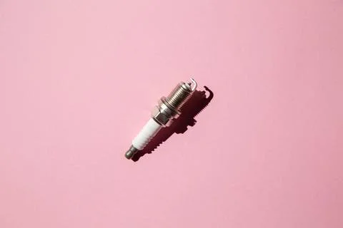 Spark plug. Car candle lies against a pink background. Auto engine electricia Stock Photos