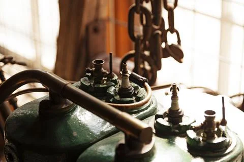 Spark plug with cord mounted to an old engine with green fuel tank Fotos de archivo