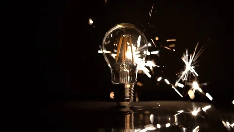 Sparkler Behind LED Light Bulb Slow Motion With Sparks Out of Focus 库存影片 99122095