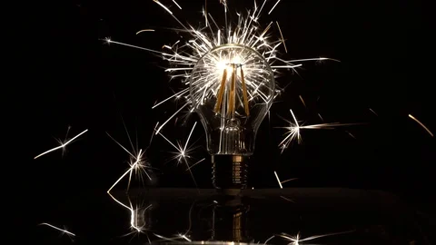 Sparkler Behind LED Light Bulb with sharply focused sparks 库存影片 99122111