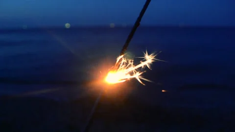 Sparkler Bengal fire burning on background of sea at night Sparks burning bengal 库存影片 239855909