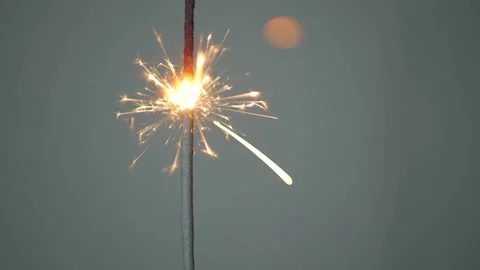 A sparkler burning down on a gray background, static shot. Holiday concept Stock Footage 146491088