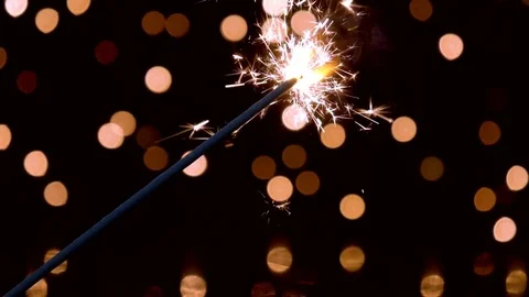 Sparkler burning in front of ambient lights in slow motion Stock Footage 81793713