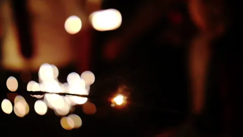 Sparkler burning in slow motion at party super close with lights and sparks Stock Footage 150674090