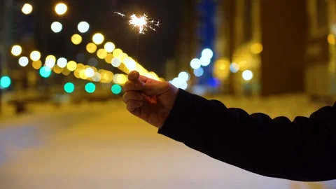 Sparkler in hand at night on the background of lights Video stock 133908524