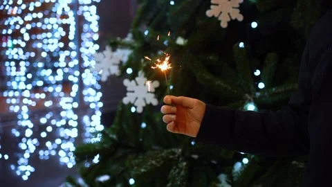 Sparkler in hand at night on the background of lights Stock Footage 133908864