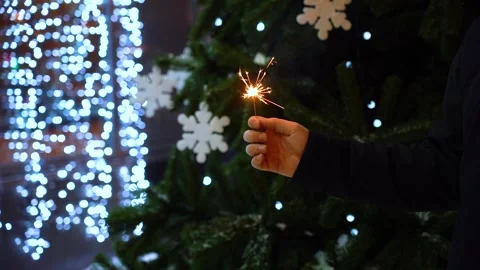 Sparkler in hand at night on the background of lights Stock Footage 133908952