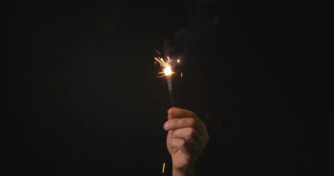 Sparkler in a man's hand on black background Stock Footage 142238192