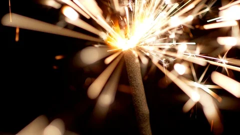 Sparkler stick burning with fire dropping sparks everywhere in darkness during Stock Footage 115907330