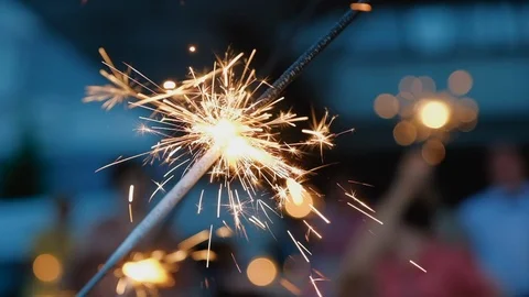 Sparklers close up, orange lights fall on all sides. Bright burning wand of Stock Footage 119032056