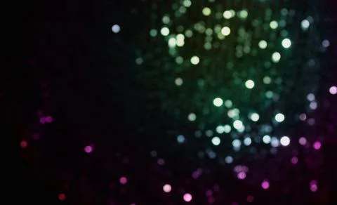 Sparkles multicolored shining on a dark background. Template for creative Stock Photos