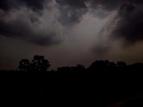 Sparkling beams of light extending from clouds during the rainy season in an Stock Photos
