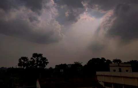 Sparkling beams of light extending from clouds during the rainy season in an Stock Photos
