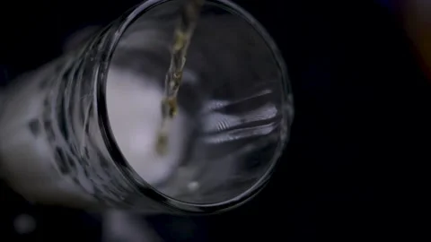 Sparkling beer served in a crystal glass on a white background in slow motion Stock Footage