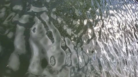 Sparkling blinking sun flares at wavy green water surface of river Stock Footage 151221960