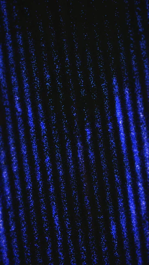 Sparkling blue diagonal lines glow against a black background 库存影片 330129526