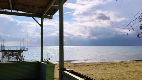 Sparkling Blue Sea and Dramatic Clouds View from a Wooden Beach Hut Porch Vídeos de archivo 332681896