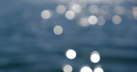 Sparkling bokeh balls out of focus background, from sun glinting on ocean Stock Footage 131104722