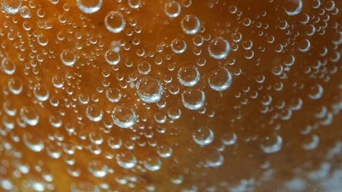 Sparkling bubbles water with a whole orange. Slow motion macro footage. 4K Stock Footage 100783327